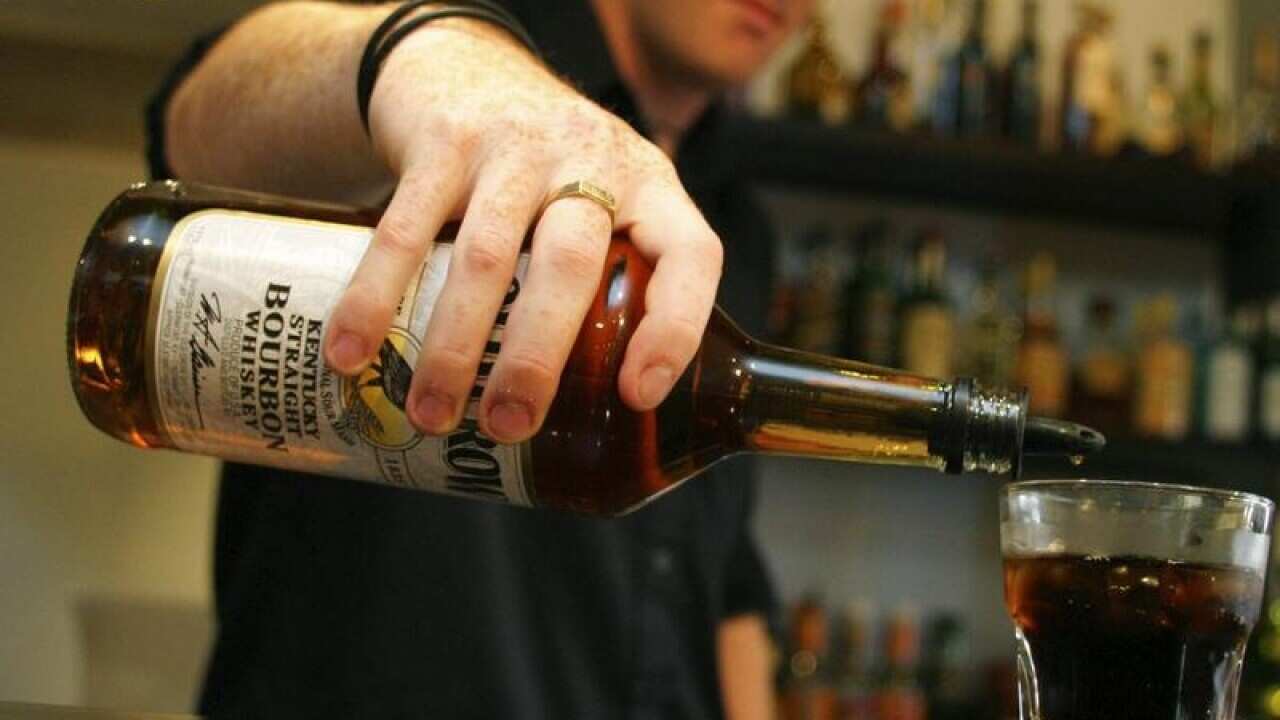 Barman pouring alcohol into a glass