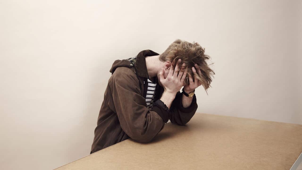 Portrait of man with his head in his hands