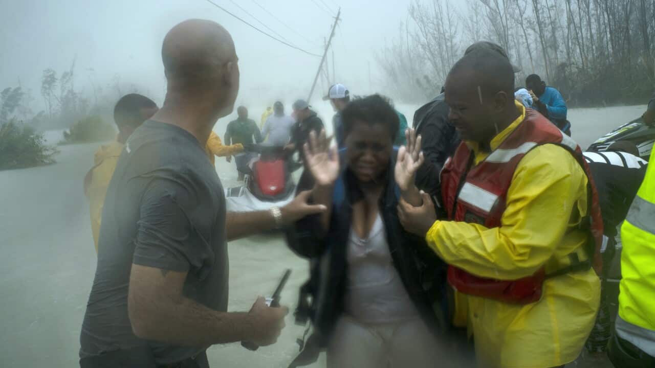 Volunteers rescue a a woman in Grand Bahama, Bahamas, Tuesday Sept. 3, 2019. 
