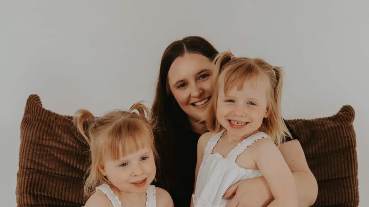 A mother with her twin daughters.