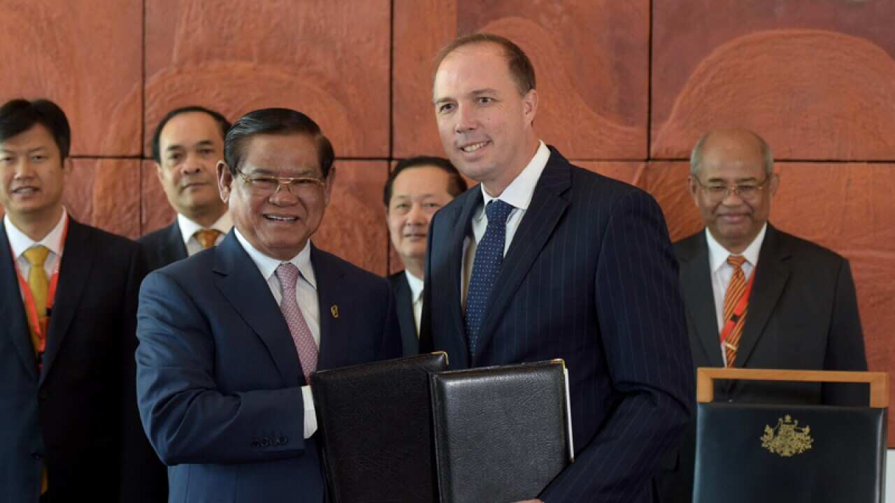 Immigration Minister Peter Dutton (R), Cambodian Deputy PM Sar Kheng