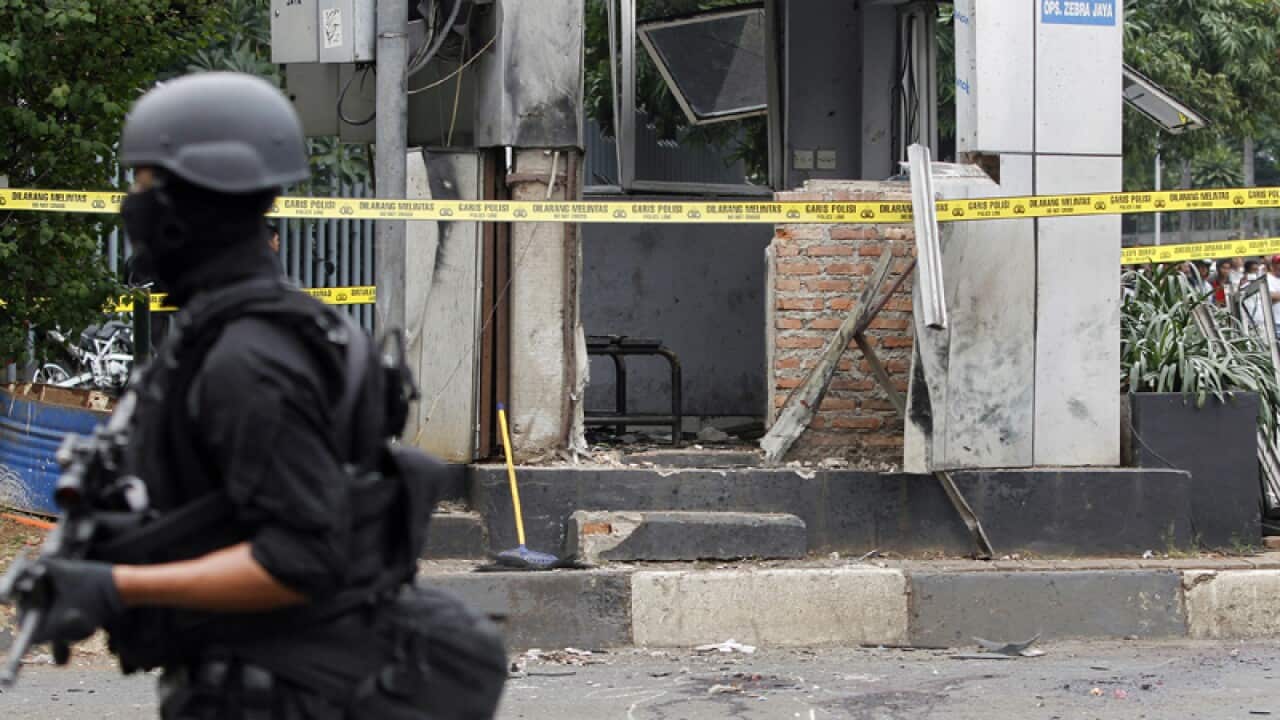 Police officers outside the scene of a bomb attack in Jakarta