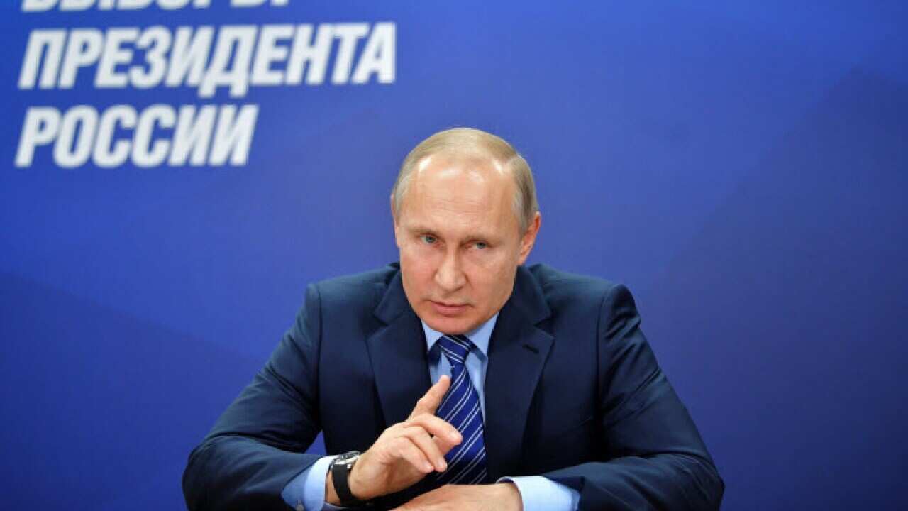 Russian President Vladimir Putin speaks at the first meeting of his campaign headquarters with the words 'Presidential Elections in Russia' in the background in Moscow, Russia