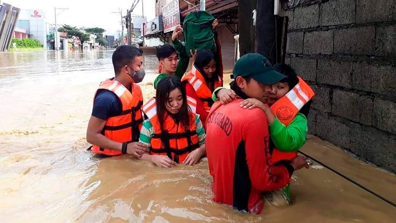 Residents wade along a flooded road during rescue operations in the Cagayan valley region, northern Philippines.