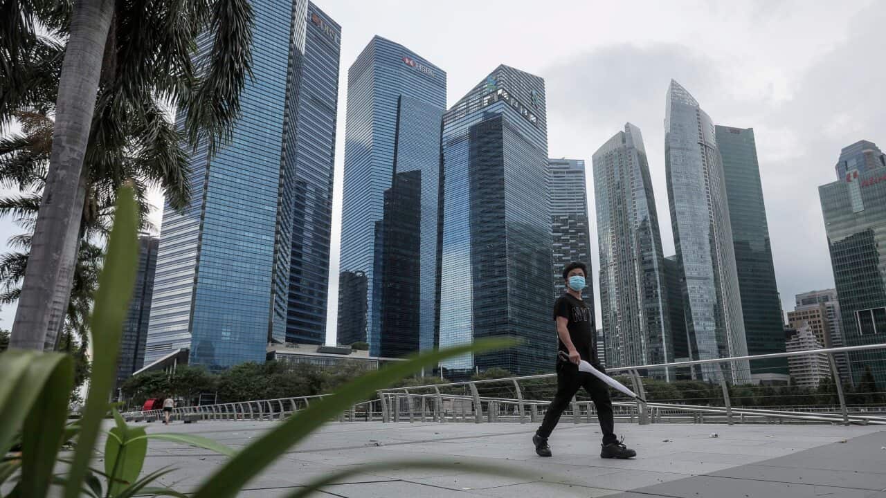 A man wearing a protective mask walks past the financial district in Singapore.