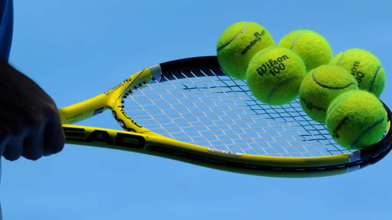 A tennis racquet and tennis balls