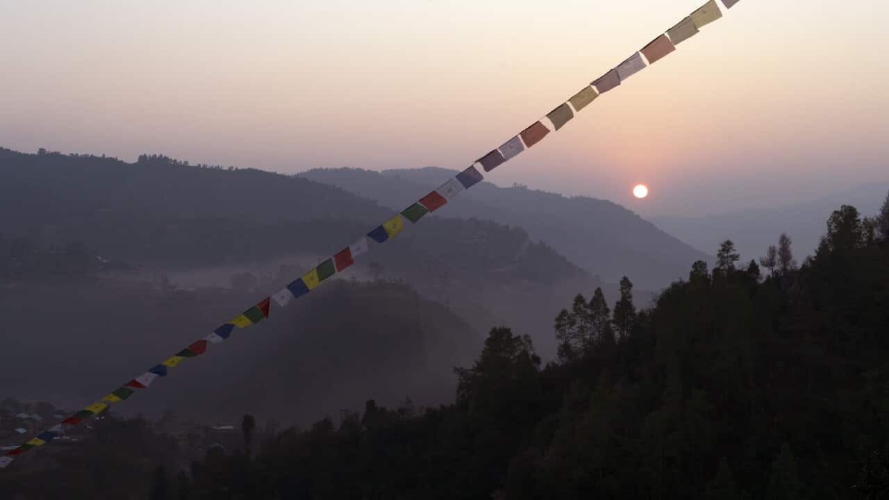 Prayer flags hanging on mountain against clear sky during sunset