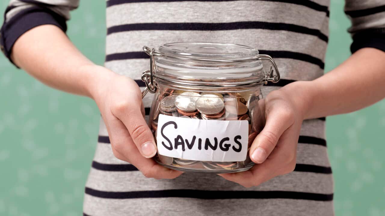 10 year old holding savings in jar