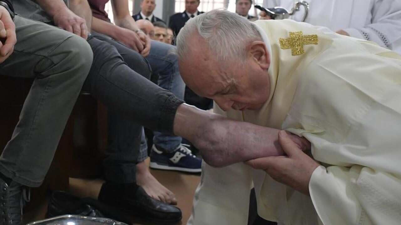 Pope Francis washes the feet of inmates during his visit to a prison near Rome.