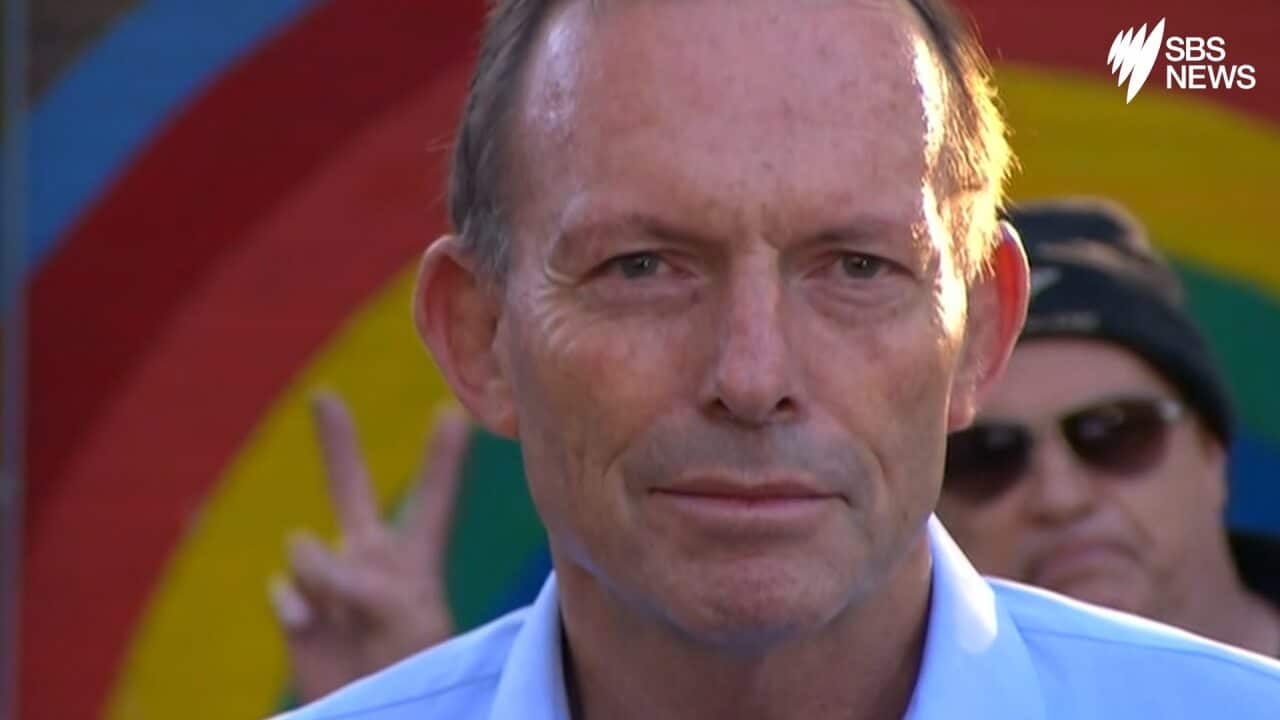 Man gives bunny fingers to Tony Abbott