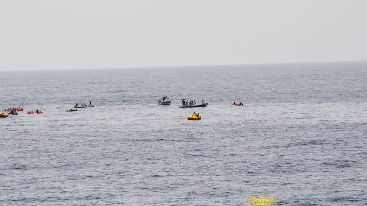 rescuers help migrants