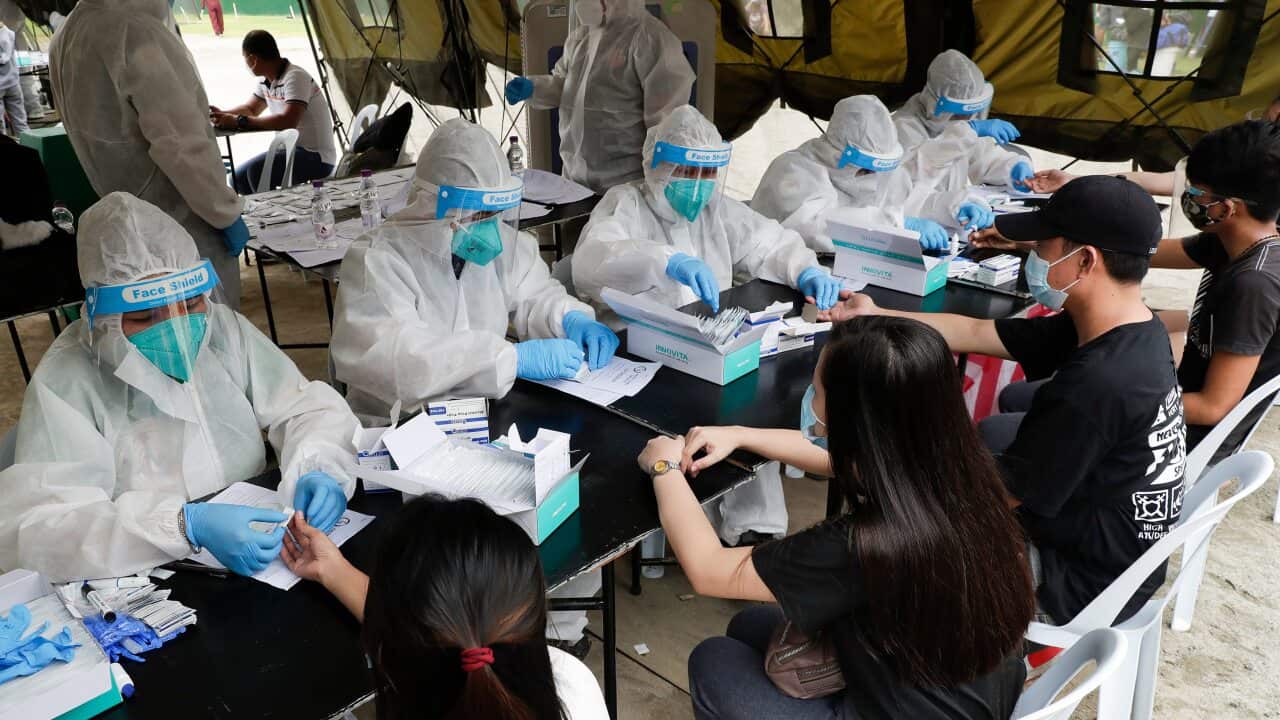 Health workers wear protective suits as they perform COVID19 rapid tests to Filipinos.