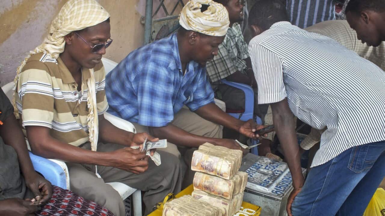 A customer of Dahabshiil, Somalia's largest remittance company, exchanges his US dollar bills for Somali shillings