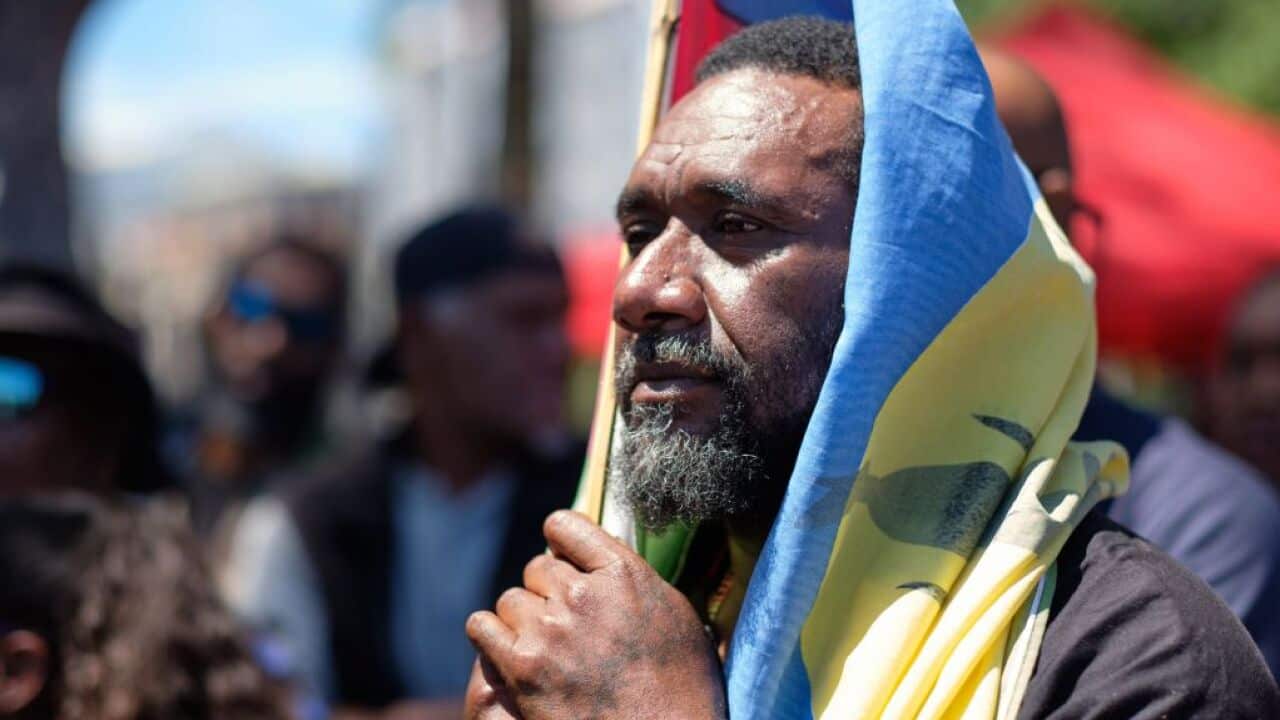 A pro-independence sympathiser with a flag of the Socialist Kanak National Liberation Front (FLNKS).
