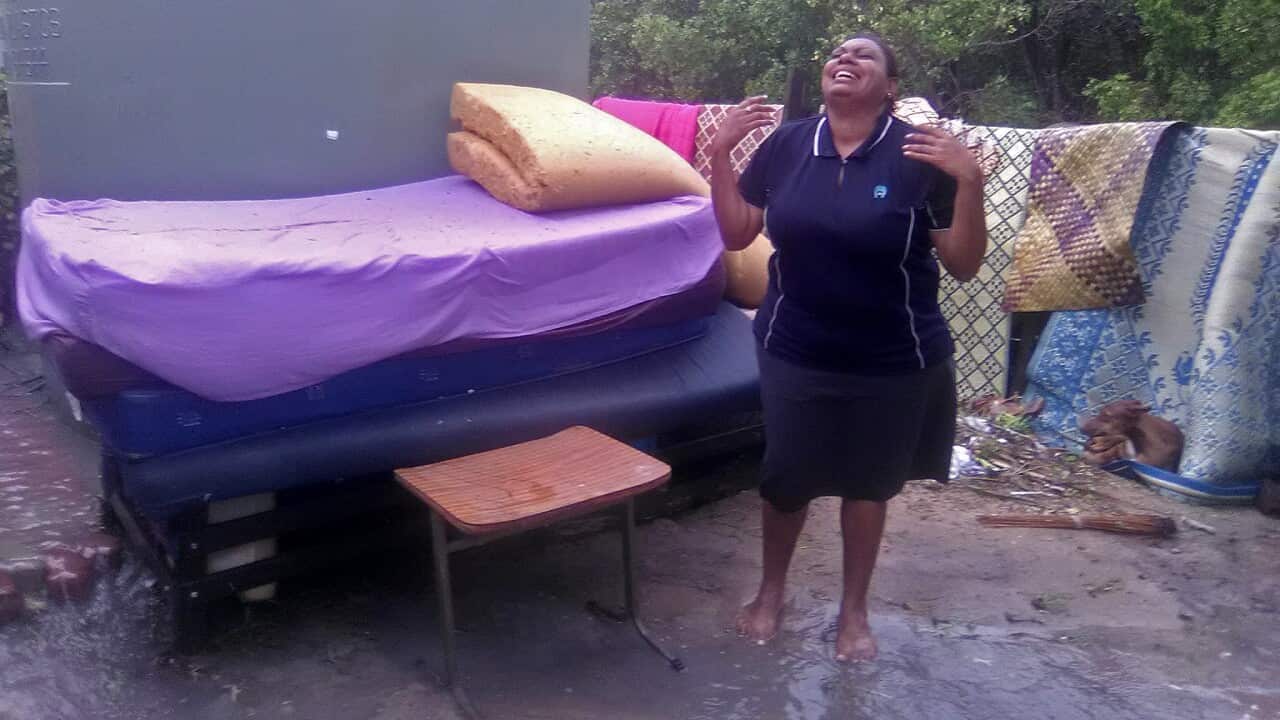 A distraught Torres Strait islander after her home is inundated with sea water from king tides.