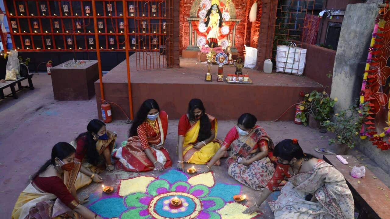 Women decorate the pandal with rangoli during Diwali in India (AAP)a