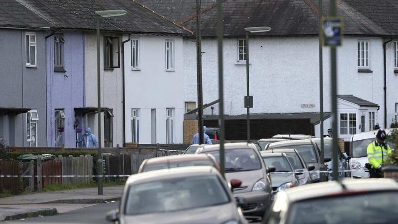 Police forensic officers work at a property in Sunbury-on-Thames.