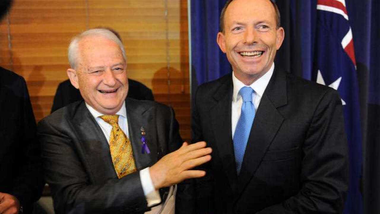 PM Tony Abbott jokes with Philip Ruddock at the launch of his book A Strong Australia in Canberra, Wednesday, Nov. 28, 2012. (AAP Image/Alan Porritt)