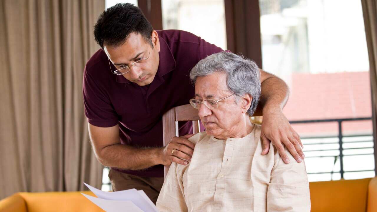 Man with old father reading a document at home