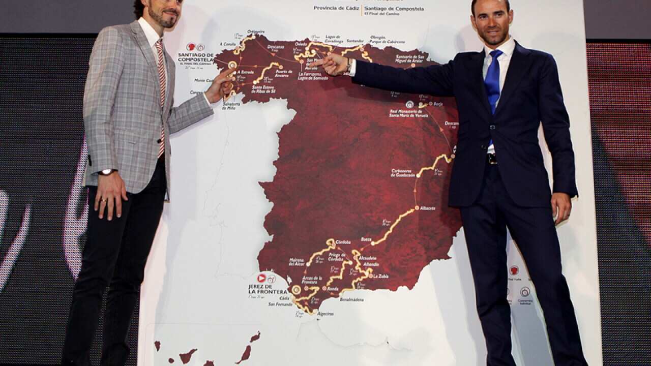Spanish cyclists pose with the Tour of Spain's route map