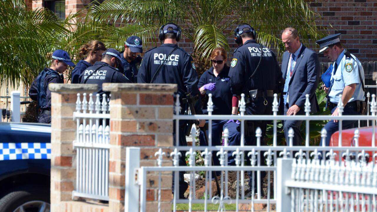  Forensic experts collect evidence from a house in the Guildford area of Sydney