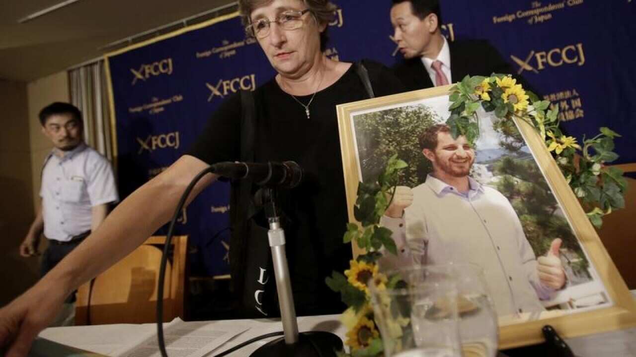 The mother of New Zealand man Kelly Robert Savage holds a portrait
