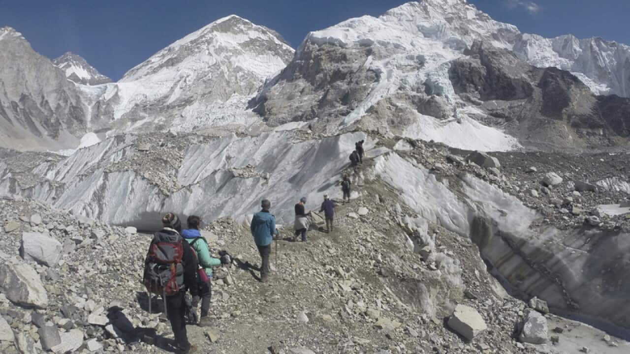 International trekkers pass through a glacier at the Mount Everest