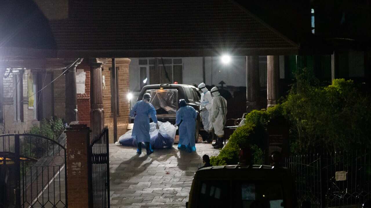 Health workers carry the dead body of COVID-19 patient at the electric crematorium in Kathmandu.
