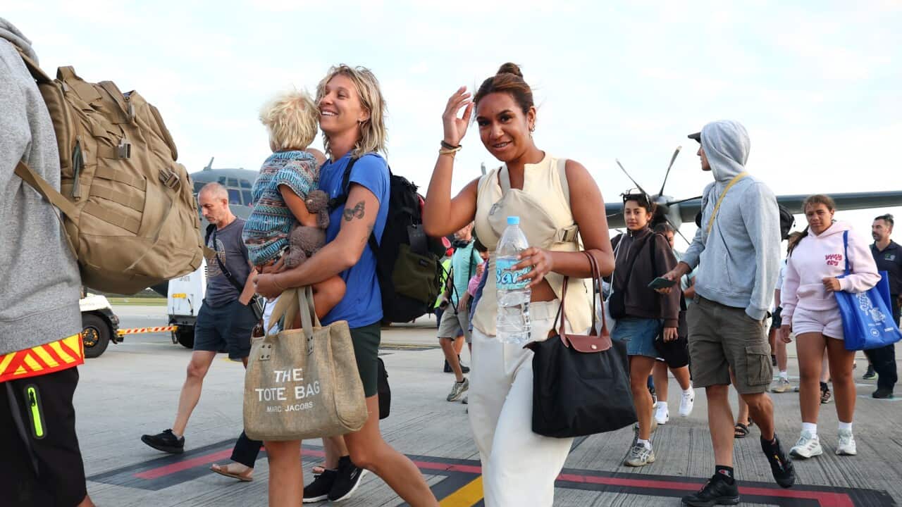 People walking across the tarmac at an airport.