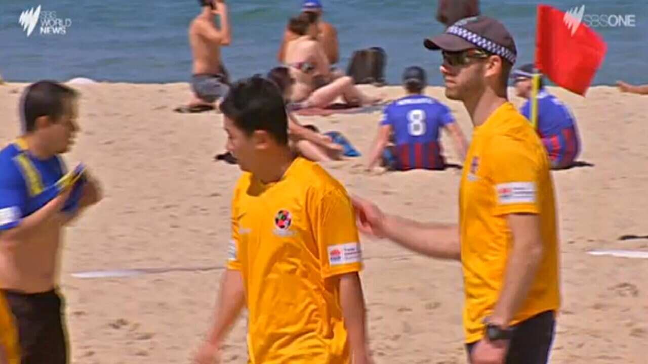 NSW Police play football against international students at Coogee beach.
