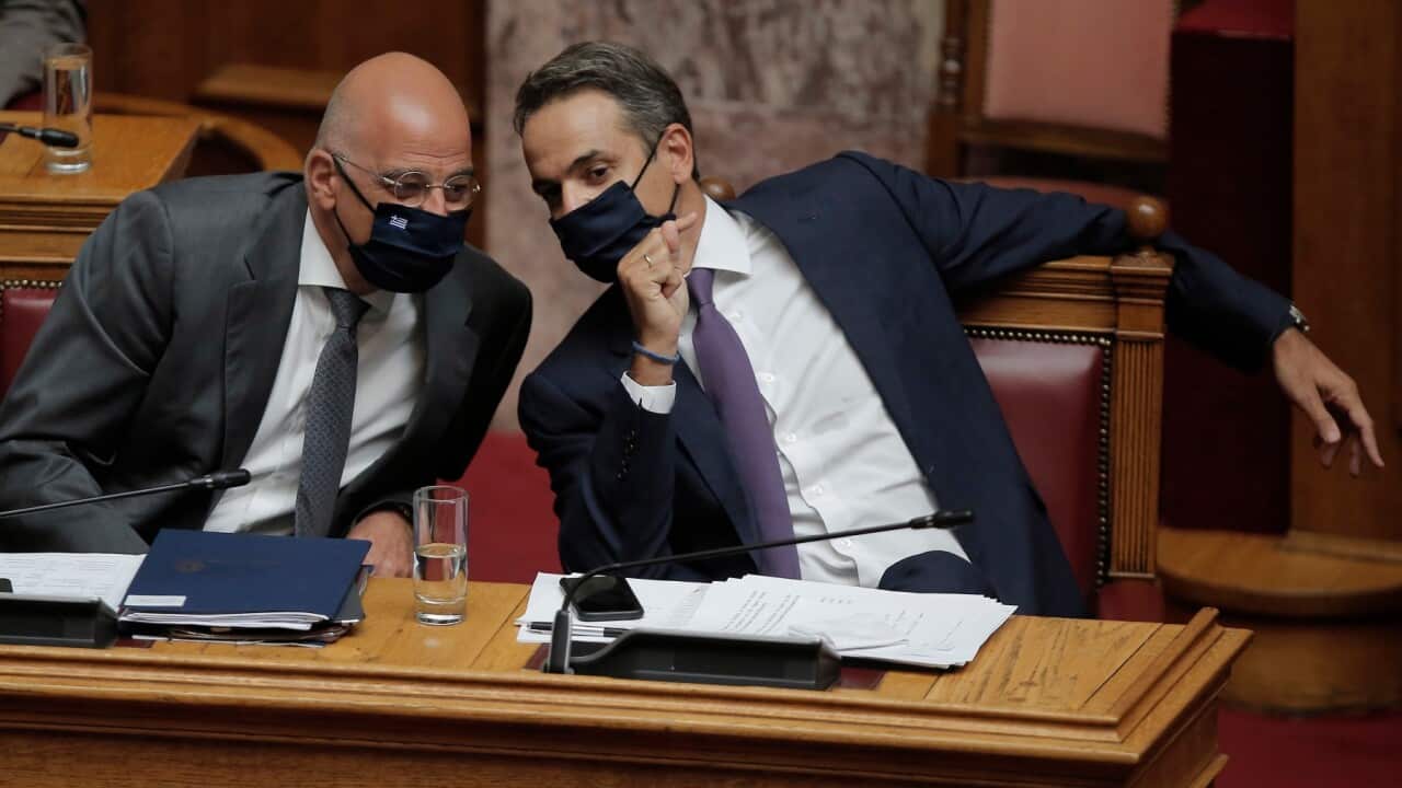 Greek Prime Minister Kyriakos Mitsotakis (R) talks with Foreign Minister Nikos Dendias (L).