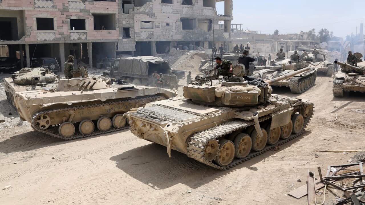 A picture taken on April 8, 2018, shows Syrian Army soldiers gathering in an area on the eastern outskirts of Douma.