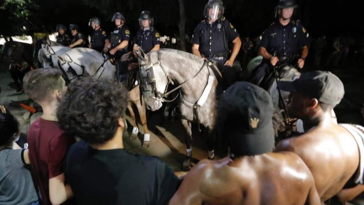 Demonstrators are pushed out of Pioneer Plaza by police