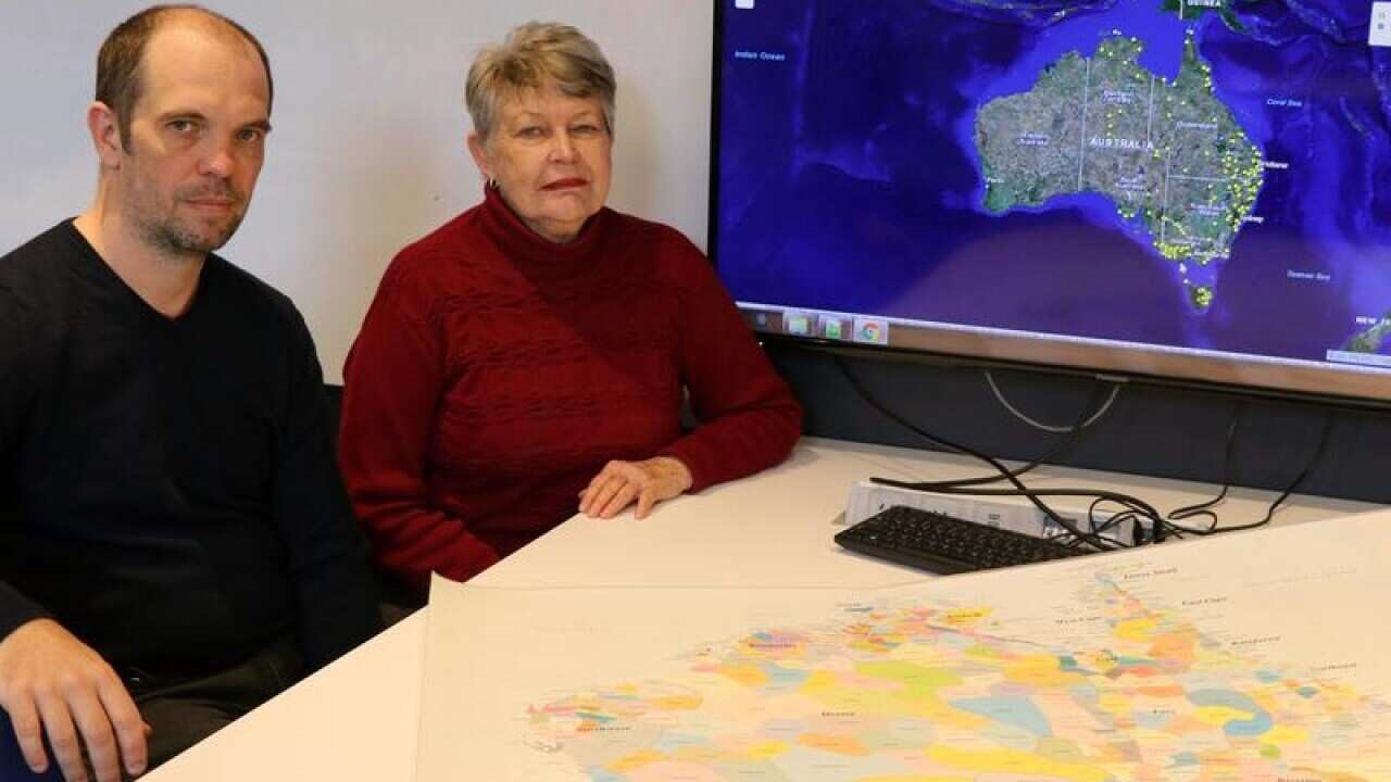 Dr Bill Pascoe and Professor Lyndall Ryan sit beside the digital map.