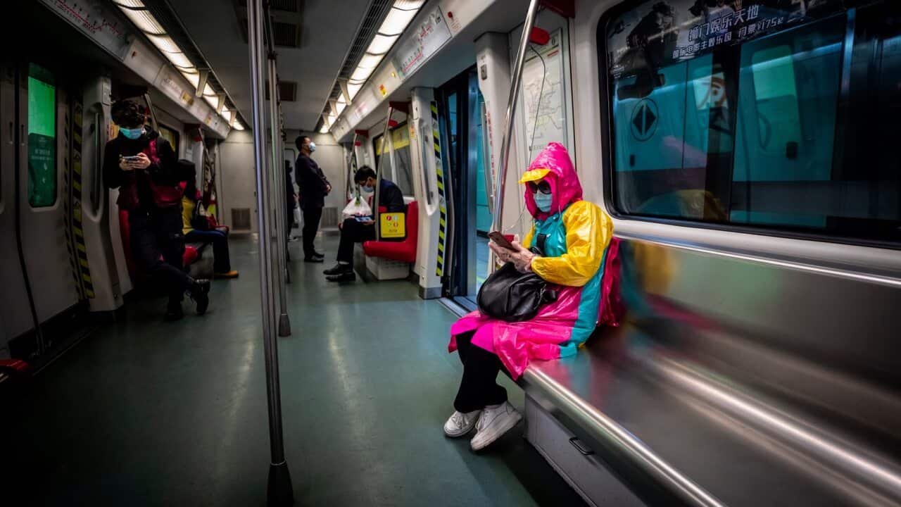 A woman in a normally busy Guangzhou subway train wearing protective gear
