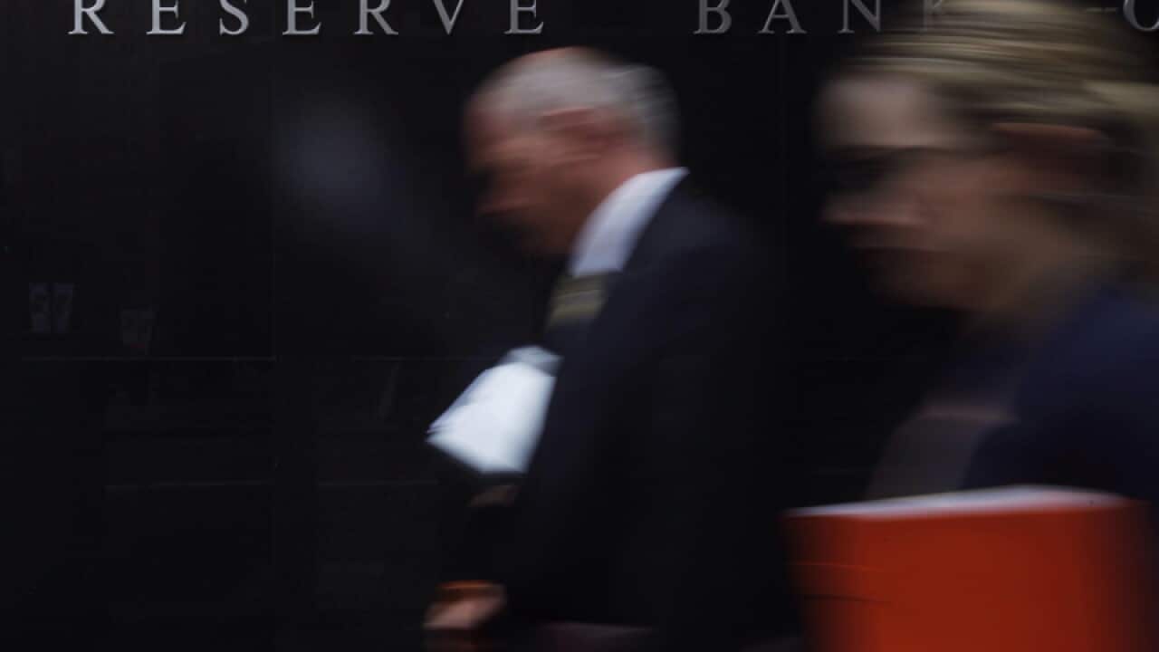 Pedestrians walk past the Reserve Bank of Australia