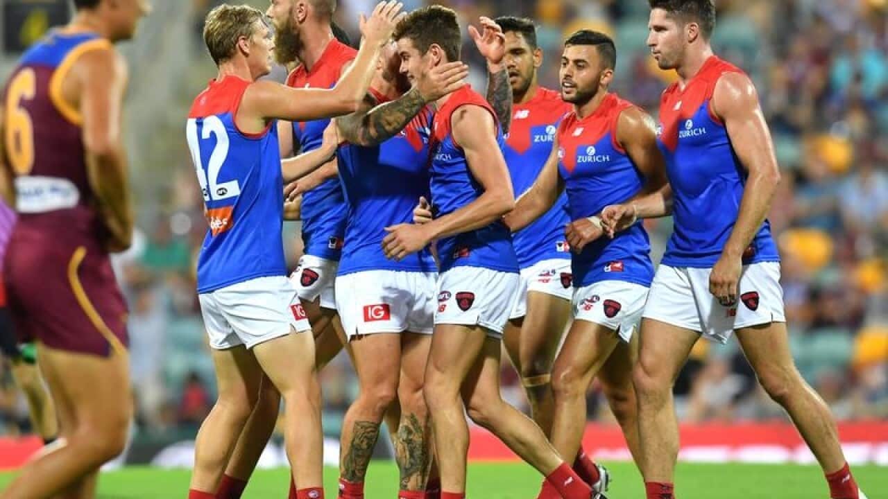 Melbourne players celebrate after kicking a goal