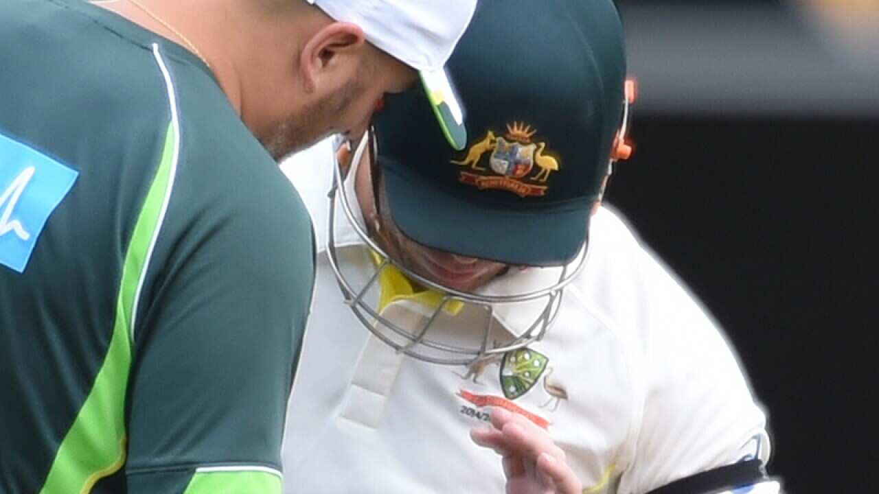 Australian batsman David Warner inspects his hand