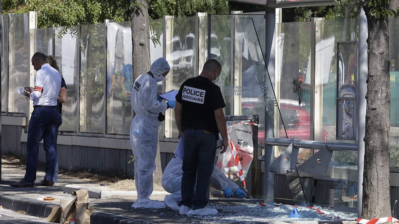 Policce officers inspect a bus stop in La Valentine