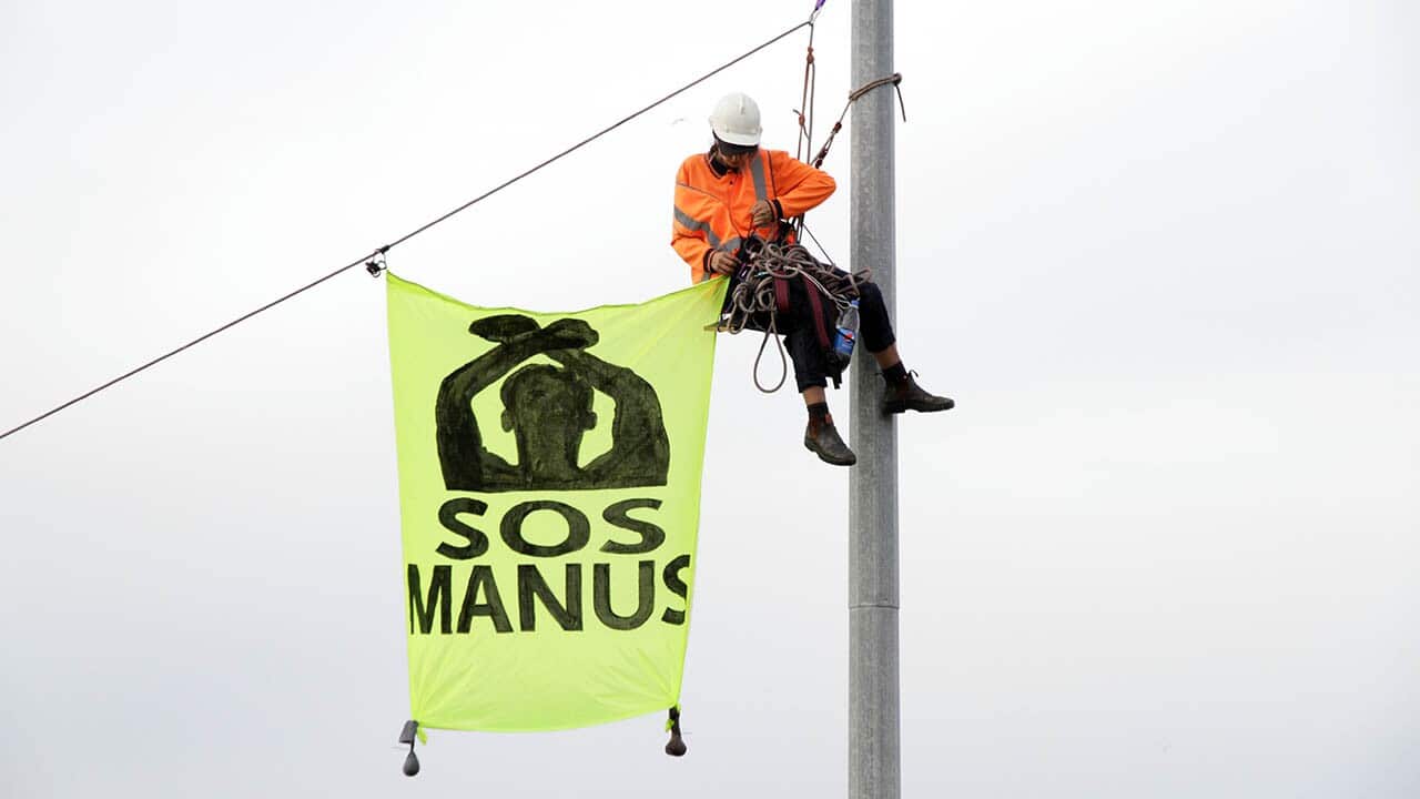 Activists block a Melbourne port container and unfurl banners.