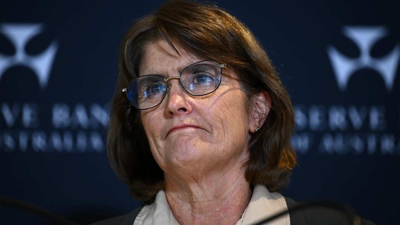 A woman wearing glasses with a dark blue headline