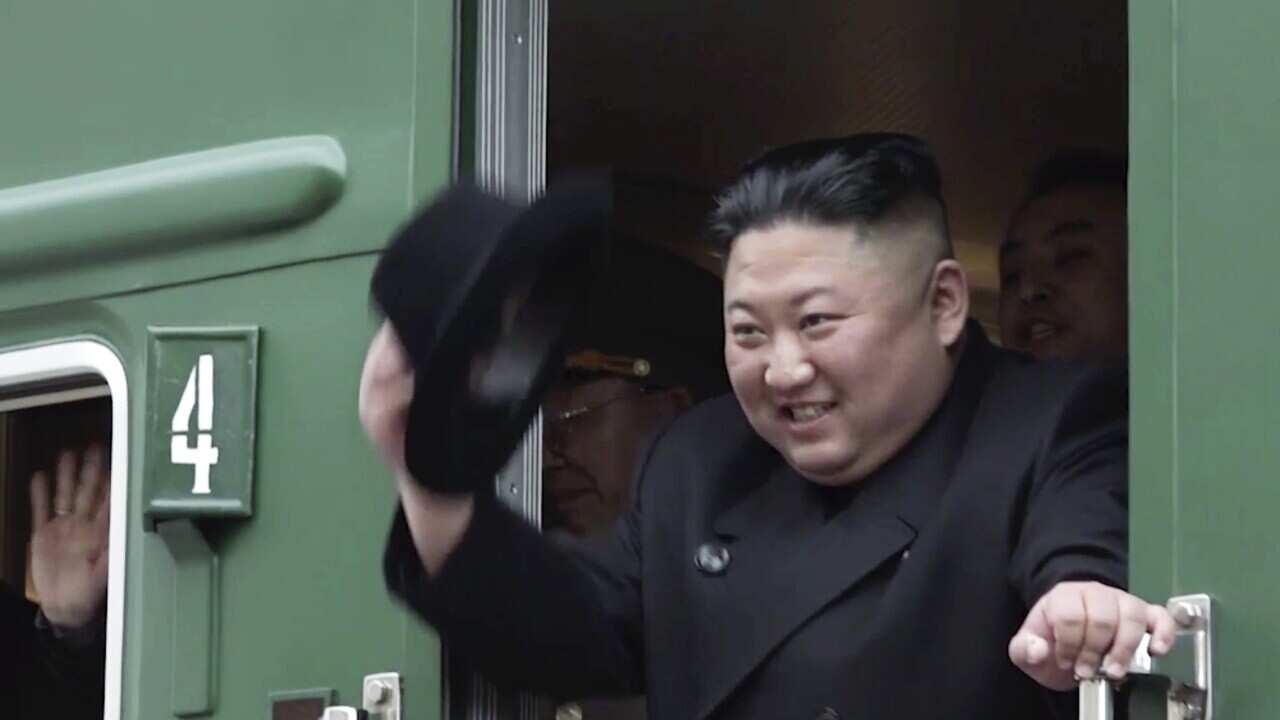 North Korean leader Kim Jong Un waves from a green train