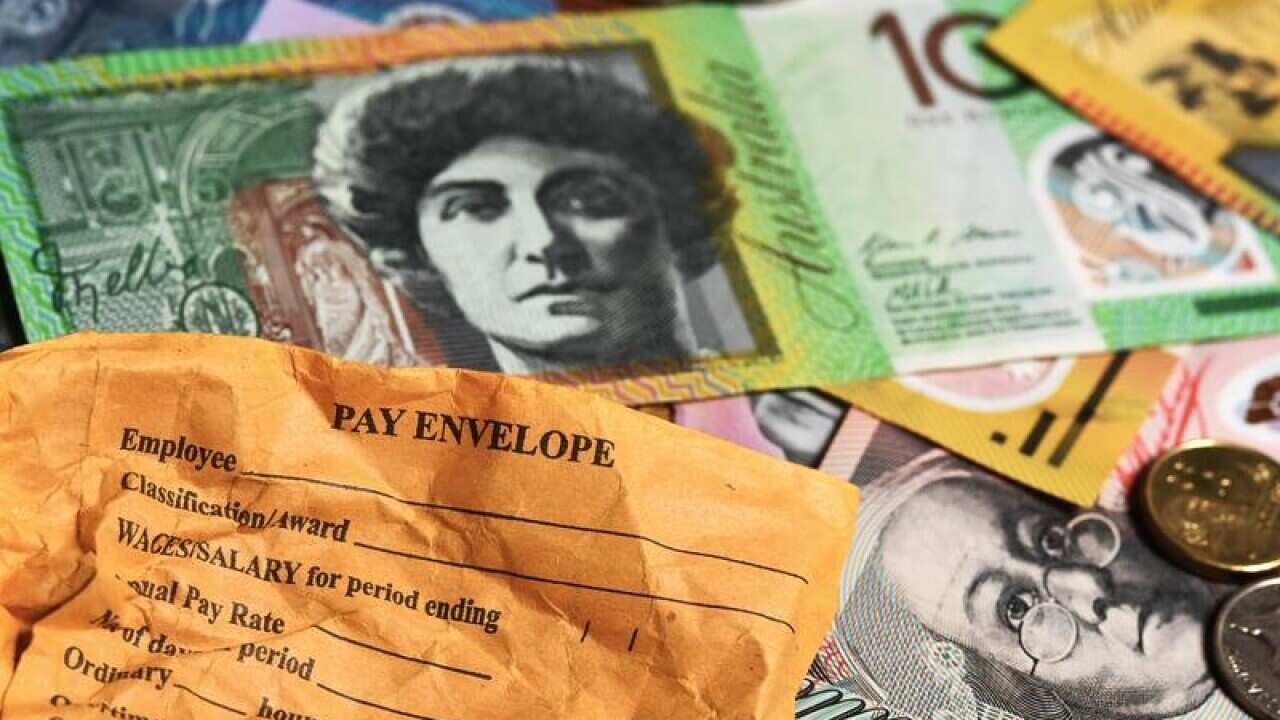 A stock photograph of Australian currency and a wages envelope .