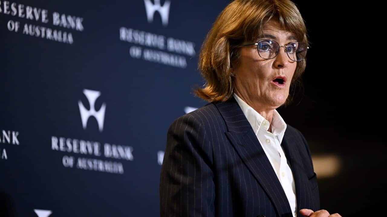 Michele Bullock, Governor of the Reserve Bank of Australia, speaking at a podium in front of a backdrop featuring the bank's logo.