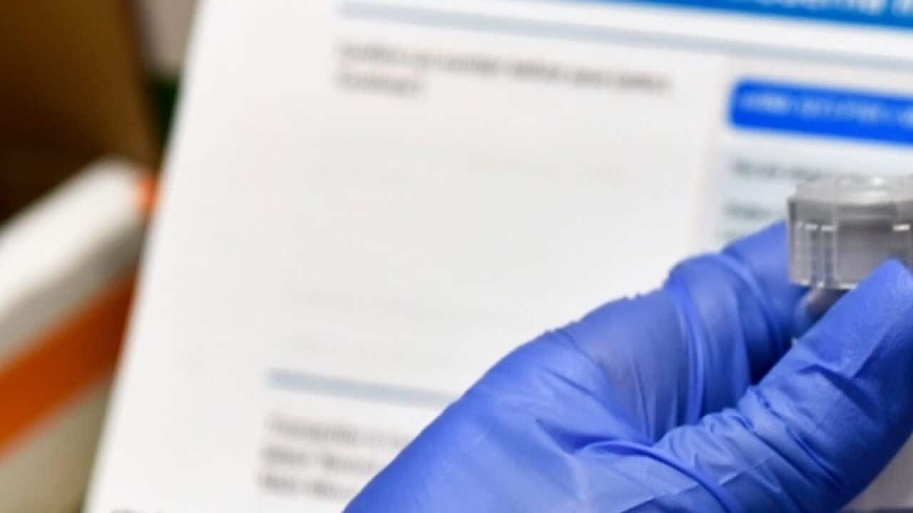 Registered Nurse Kath Olmstead prepares a blinded study experimental vaccine for COVID-19.