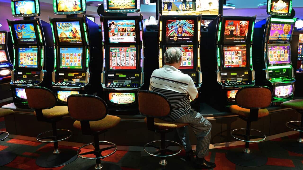 A man playing at a poker machine.