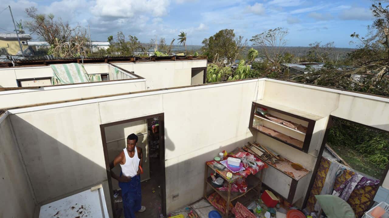 Uwen Garae surveys his destroyed house in Vanuatu