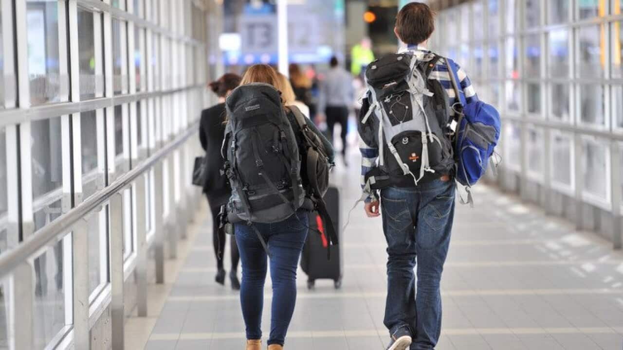 Backpackers make their way to the international terminal at Melbourne Airport in Melbourne, Wednesday, April 23, 2014. (AAP Image/Julian Smith) NO ARCHIVING
