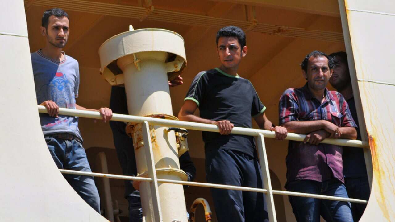 Iraqi asylum seekers lok out from a cargo ship after being rescued