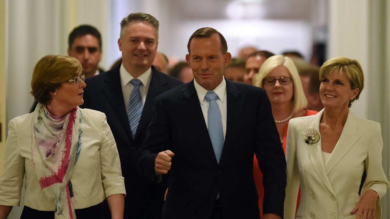 PM Tony Abbott (C) and fellow MPs arrive for a special party meeting